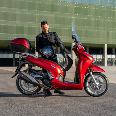 SH350i, man naast de scooter, achteraanzicht, rode motor