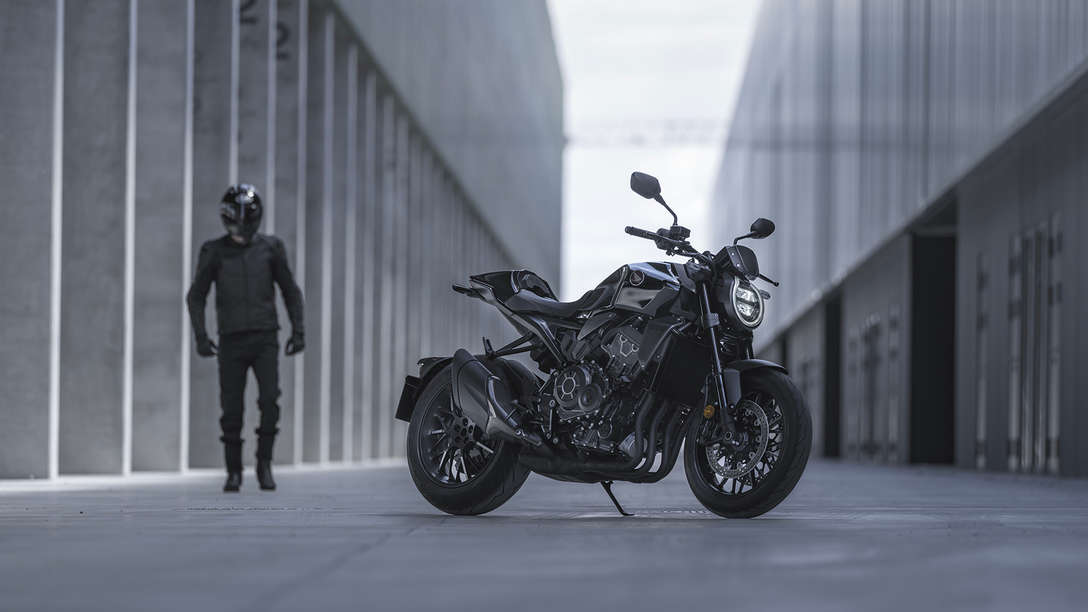 Honda CB1000R Black Edition - man naast de motor in de straat tussen de gebouwen