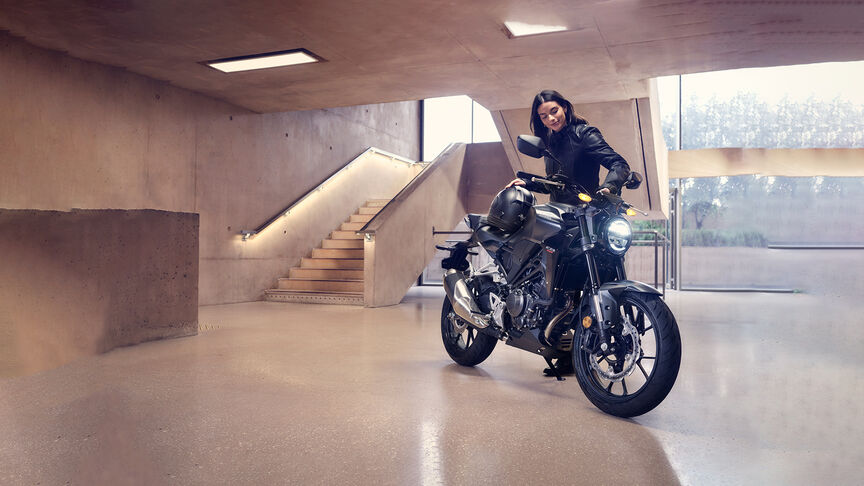 Honda CB300R driekwart vooraanzicht, bekeken door een vrouw in een studio.