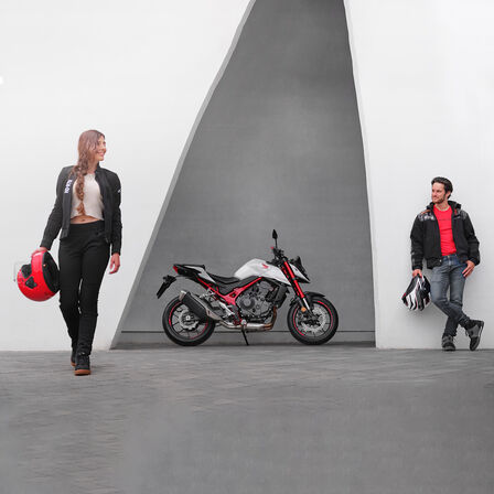 Man en vrouw leunen naast een Honda CB750 Hornet.
