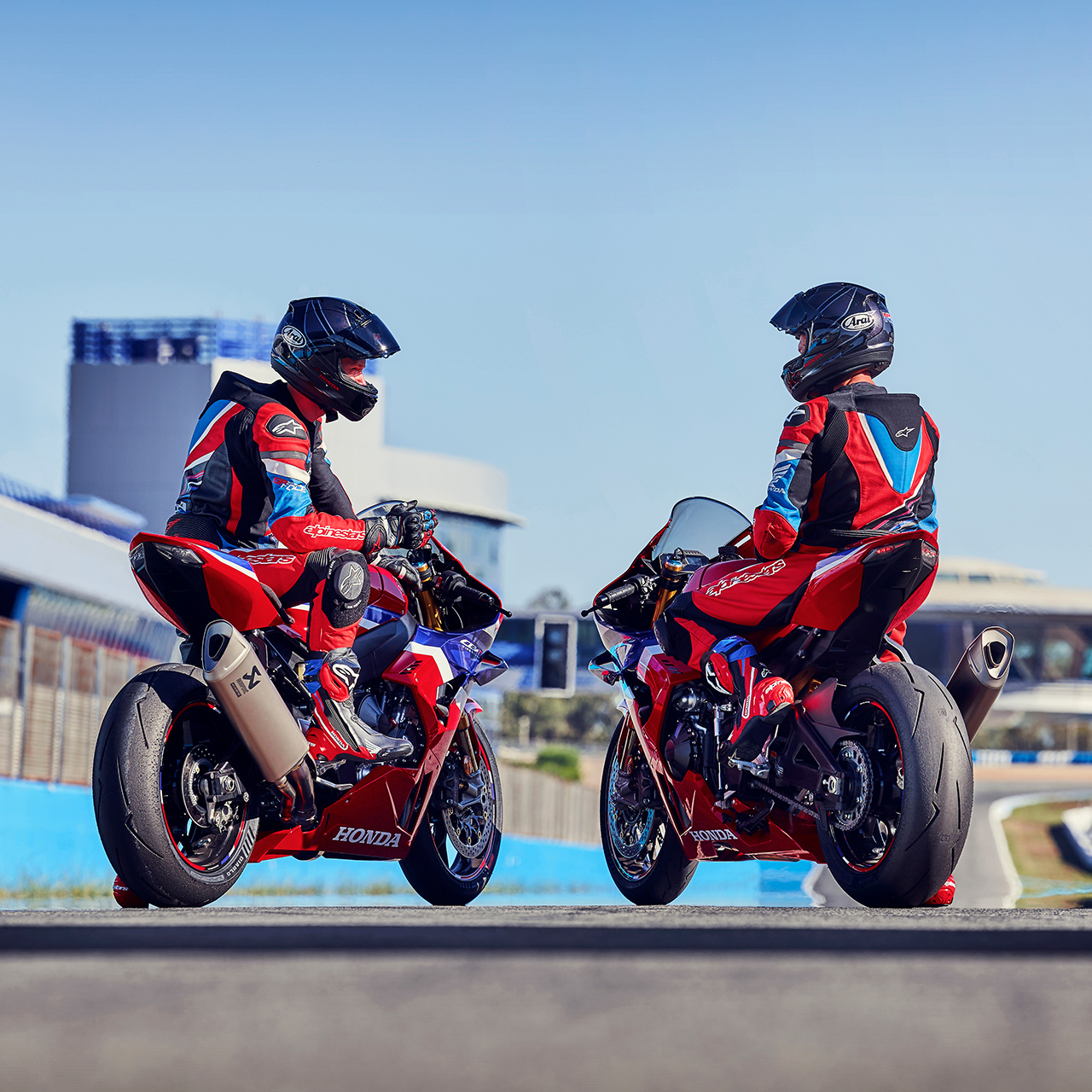 Achteraanzicht van twee rijders op de Honda CBR1000RR-R Fireblade op het circuit. 