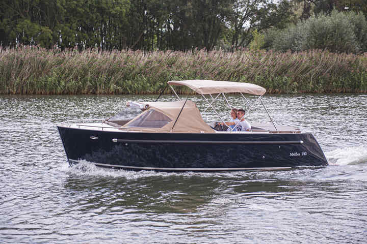 Maxima boat being driven on the thames by a man, with a honda marine outboard engine